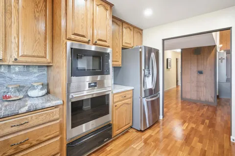 a kitchen with stainless steel appliances granite countertop a refrigerator and a stove top oven