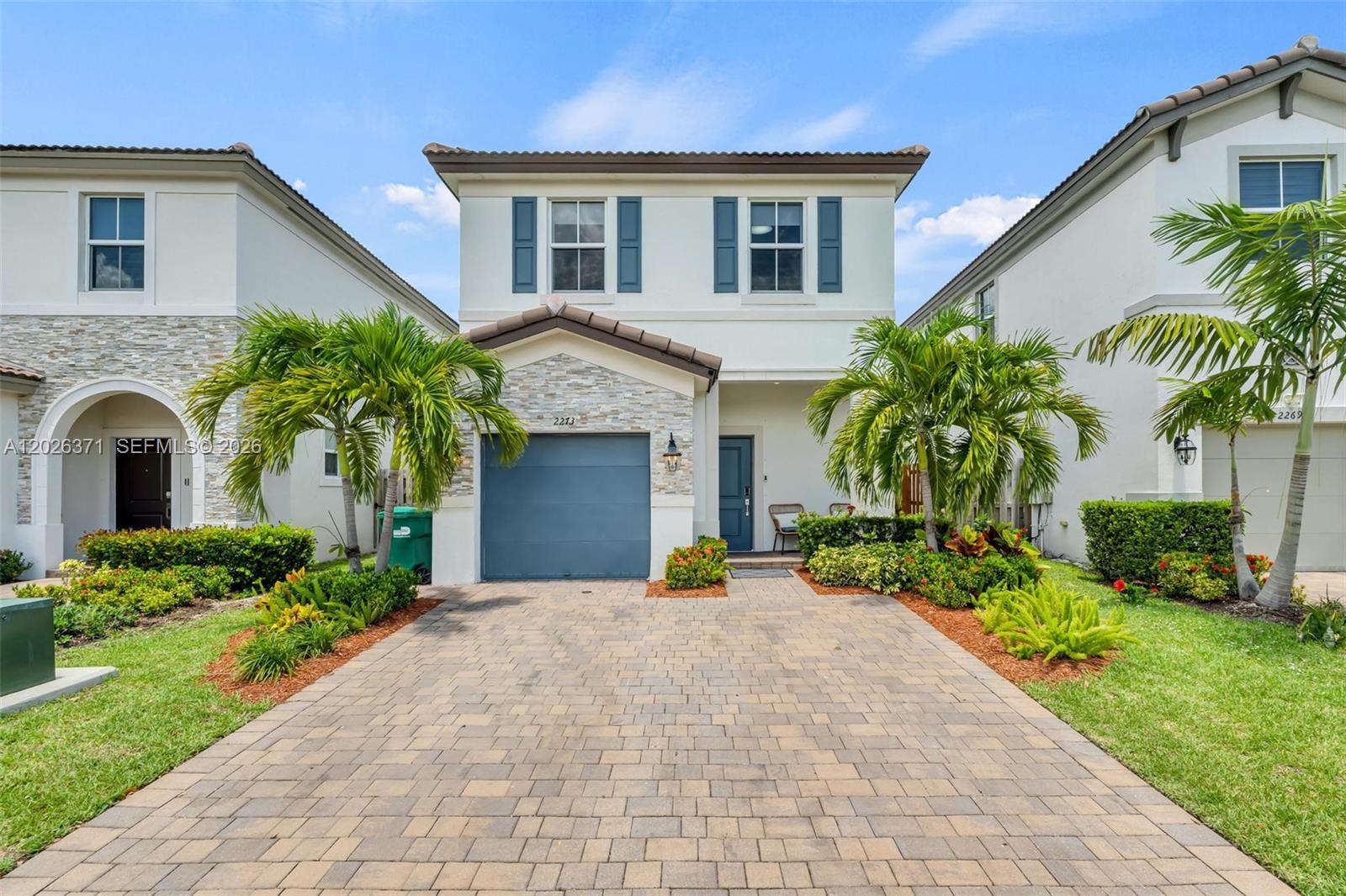 2273 Northwest 131st Circle Miami, FL 33167 - Photo 2 of 46 a front view of a house with a yard and potted plants