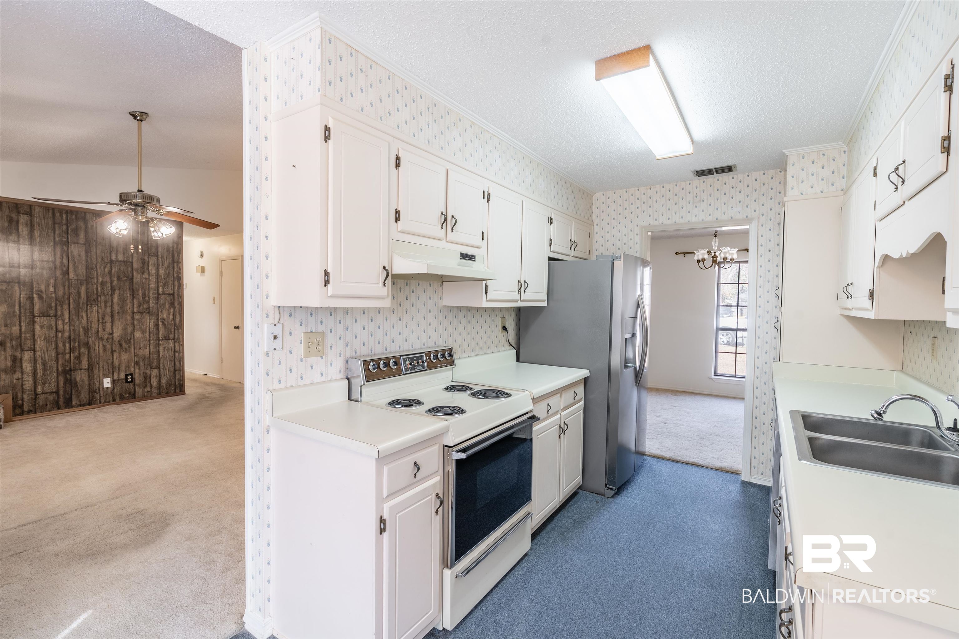 9751 Pine Knoll Road Mobile, AL 36608 - Photo 9 of 36 Kitchen with electric range, light countertops, a textured ceiling, dark carpet, and a ceiling fan