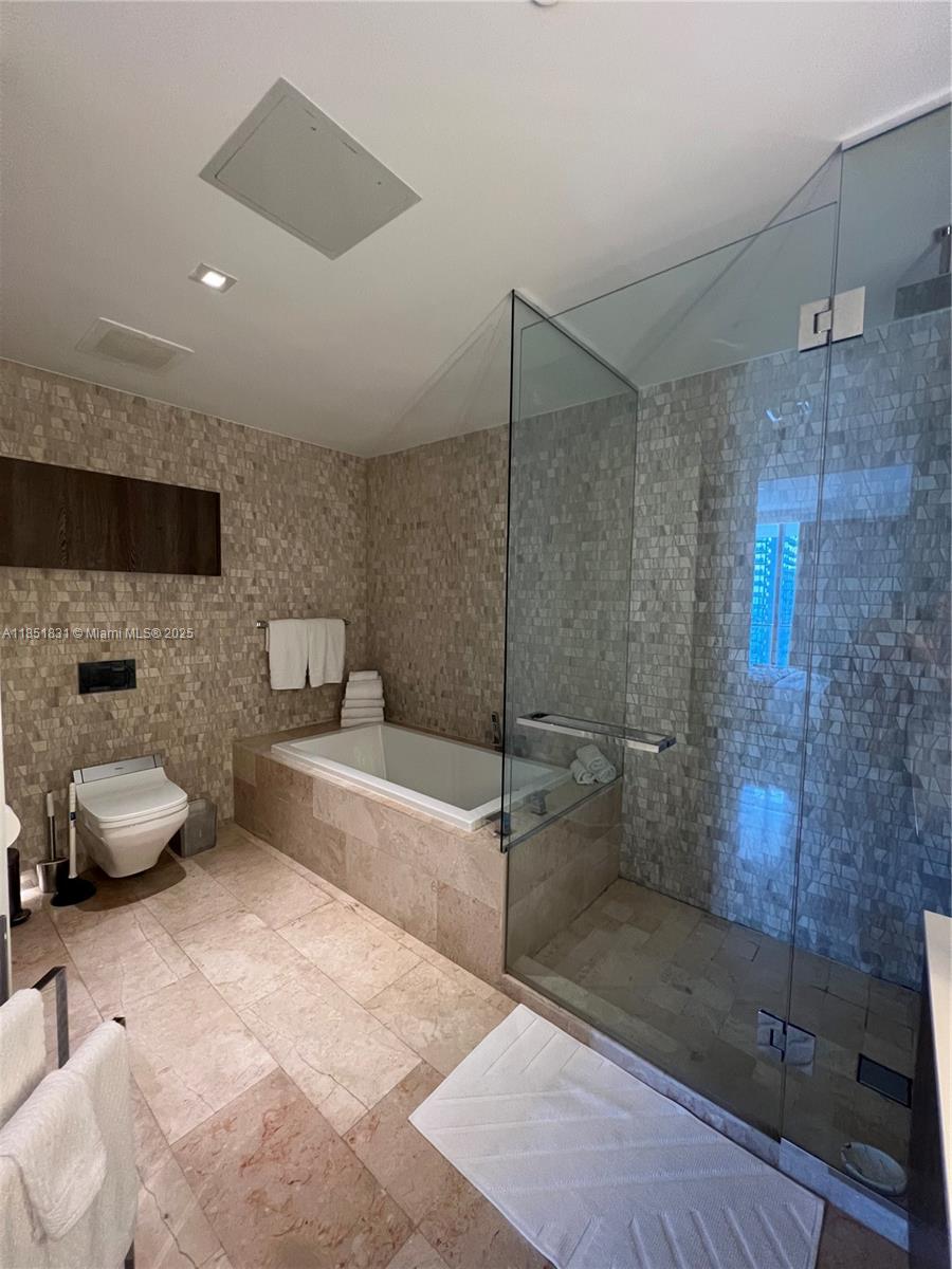 88 Southwest 7th Street, Unit 3007 Miami, FL 33130 - Photo 12 of 36 a bathroom with a tub sink and toilet