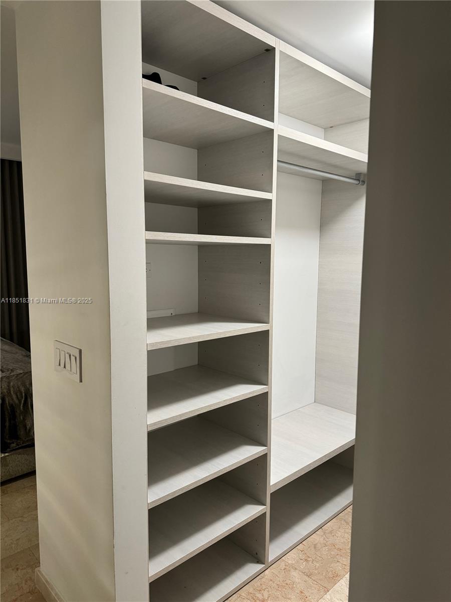 88 Southwest 7th Street, Unit 3007 Miami, FL 33130 - Photo 14 of 36 a view of walk in closet with empty racks