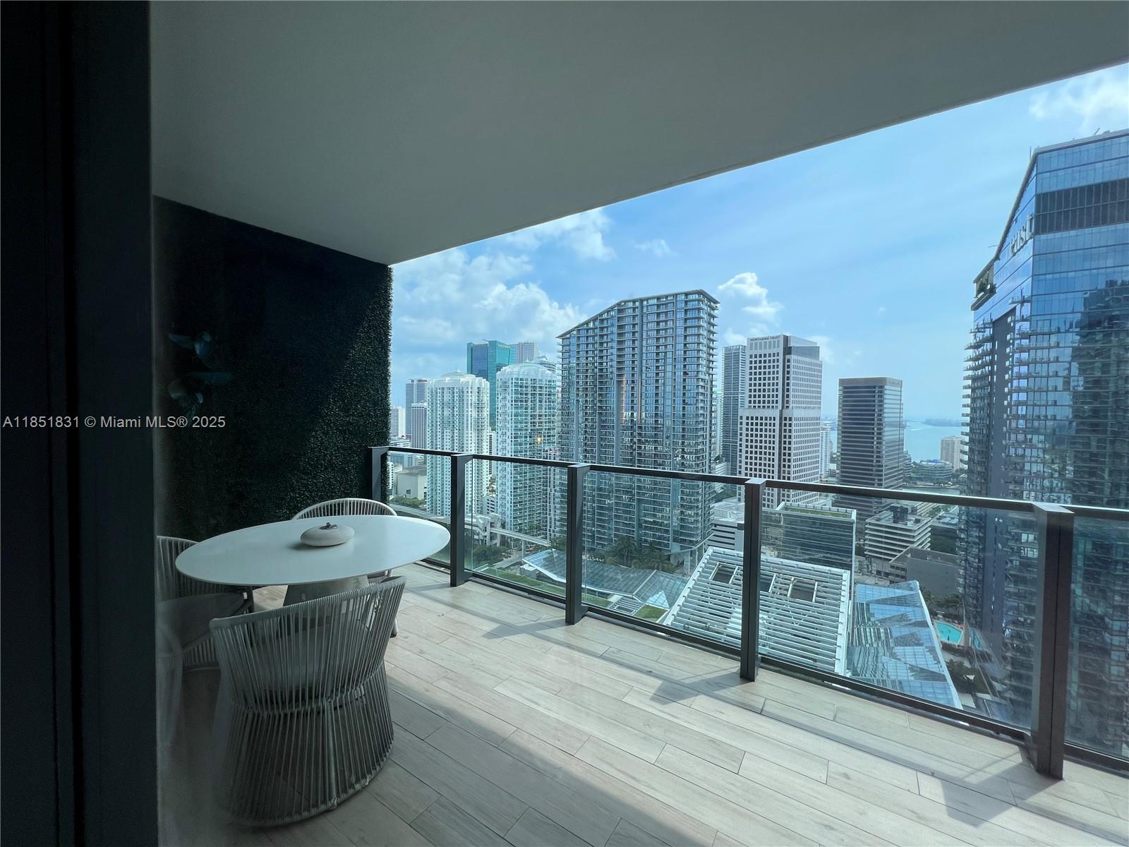 88 Southwest 7th Street, Unit 3007 Miami, FL 33130 - Photo 18 of 36 a view of a balcony with chair and wooden floor