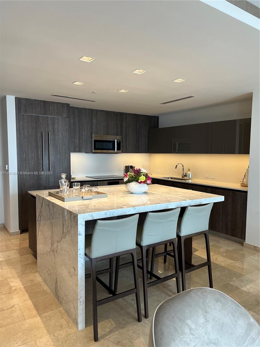 88 Southwest 7th Street, Unit 3007 Miami, FL 33130 - Photo 7 of 36 a kitchen with a table chairs sink and cabinets