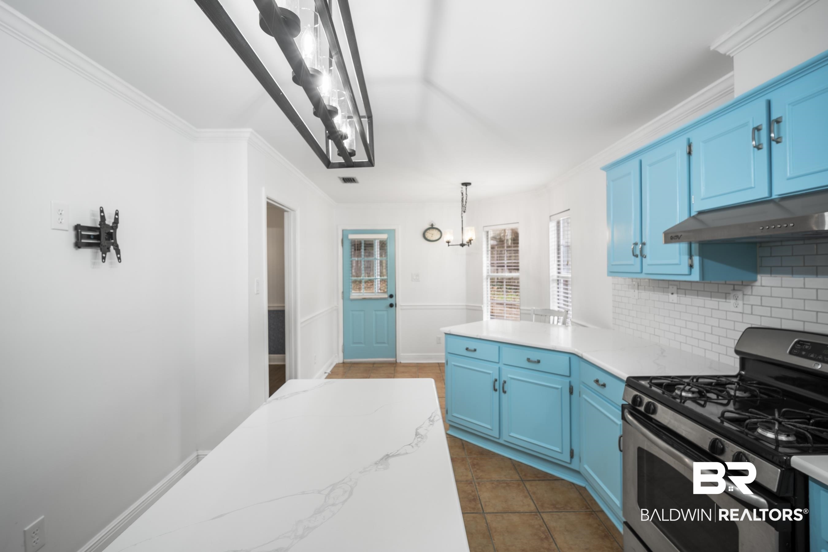 3101 Autumn Ridge Drive West Mobile, AL 36695 - Photo 5 of 36 Kitchen with stainless steel gas range, blue cabinetry, crown molding, pendant lighting, and light stone countertops