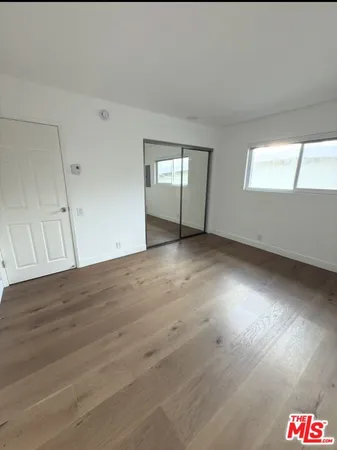an empty room with windows and cabinet
