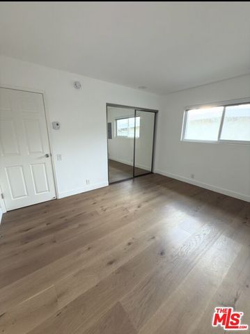 an empty room with windows and cabinet