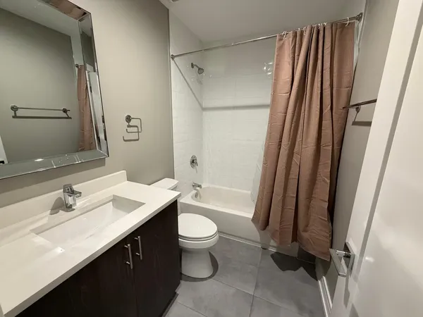 a bathroom with a sink a toilet a mirror and shower