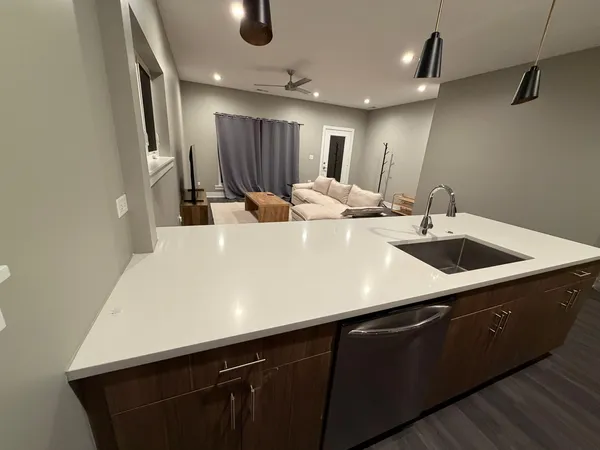 a large kitchen with a sink and a refrigerator