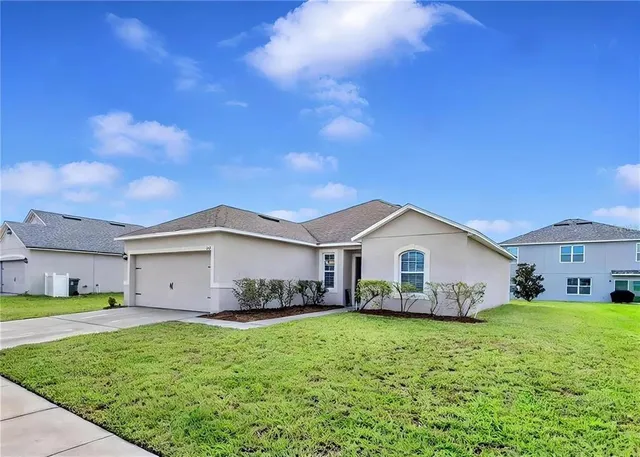 a front view of a house with a garden and yard