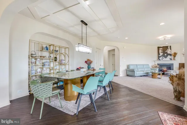 a dining room with furniture a chandelier and wooden floor