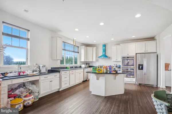a kitchen with stainless steel appliances a refrigerator and wooden floor