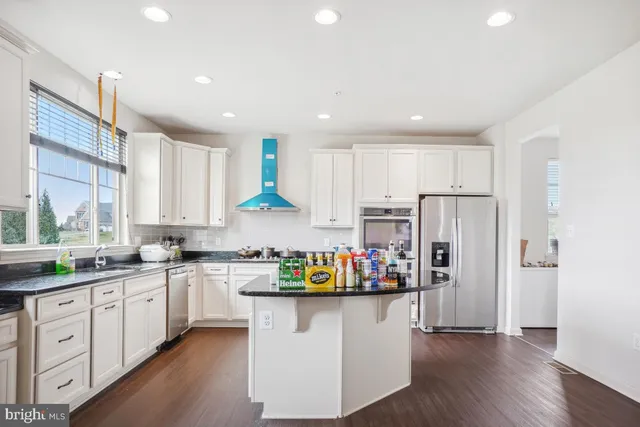 a kitchen with stainless steel appliances granite countertop a refrigerator sink and cabinets