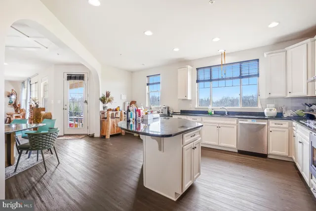 a kitchen with granite countertop a sink cabinets and wooden floor