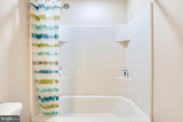 a spacious bedroom with a bed and wooden floor