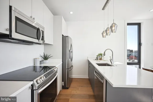 a kitchen with stainless steel appliances granite countertop a sink and a microwave