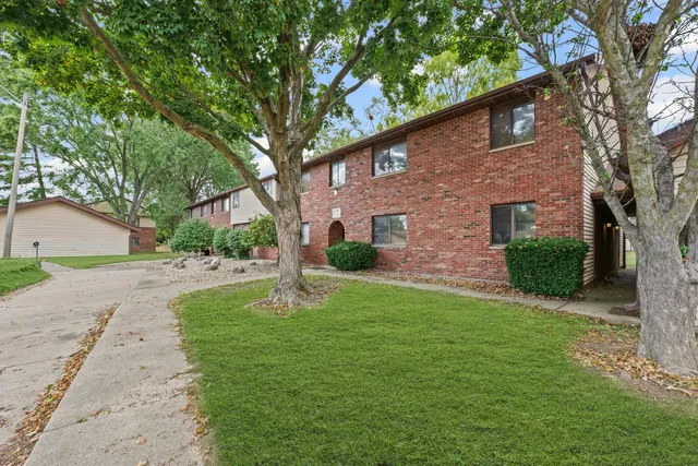 a view of a yard in front of a house with large tree