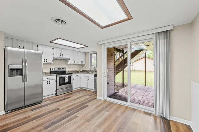 a kitchen with granite countertop a refrigerator a sink and a stove top oven