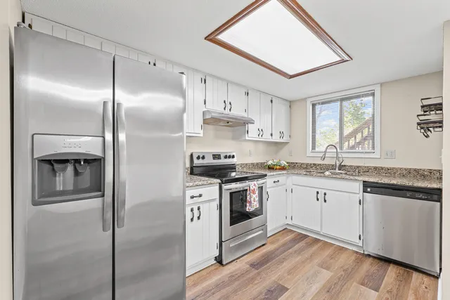 a kitchen with stainless steel appliances granite countertop a stove a sink and a refrigerator