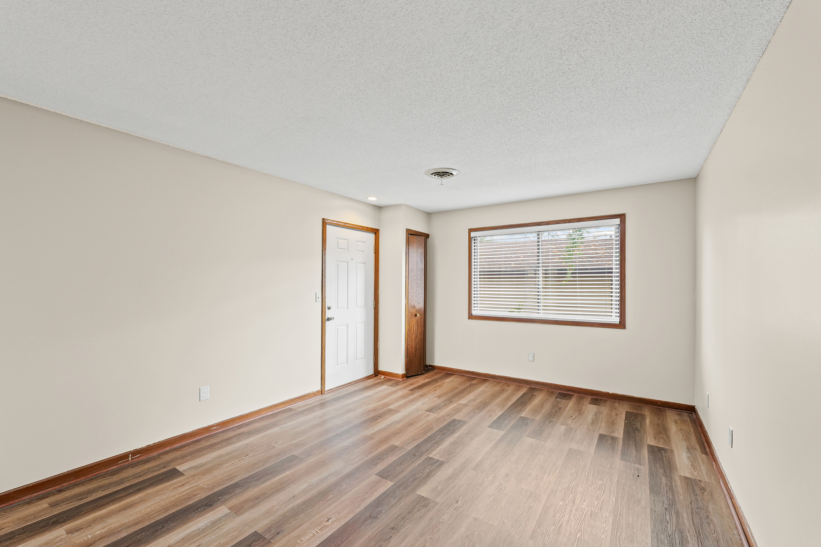 1304 Christopher Circle, Unit 1 Urbana, IL 61802 - Photo 5 of 18 a view of an empty room with wooden floor and a window