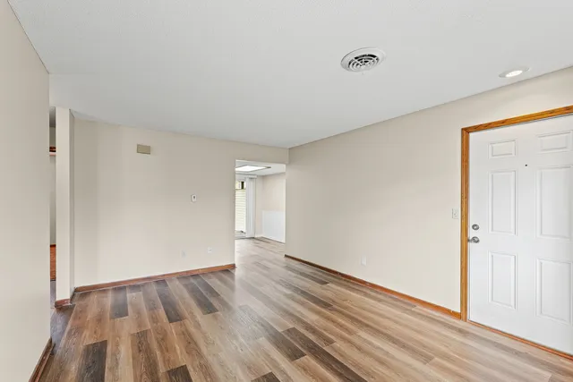 a view of an empty room with wooden floor