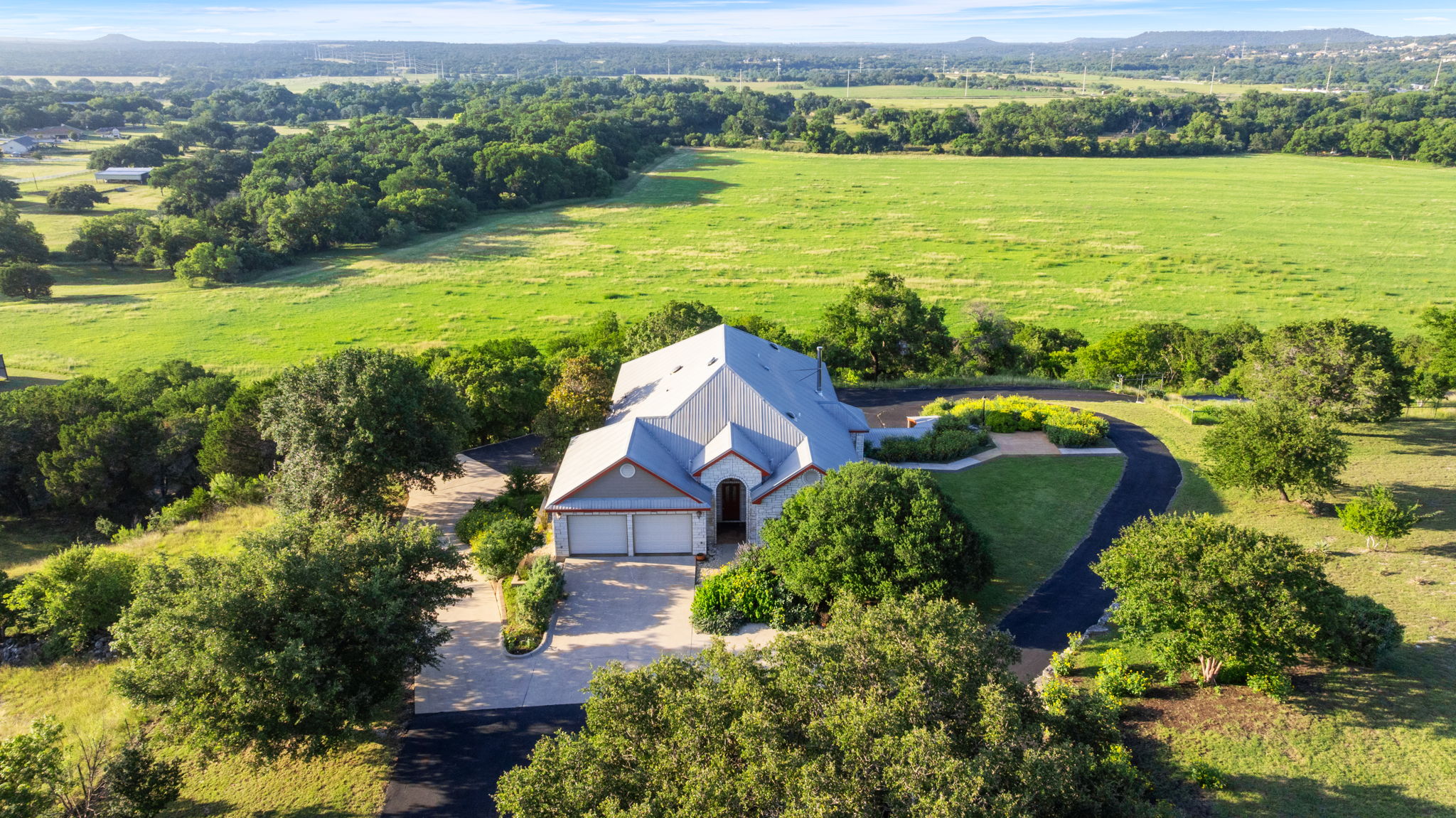 1427 River Ridge Ranch Road Killeen, TX 76549 - Photo 1 of 40 An aerial perspective reveals a secluded residence nestled amongst a vast, verdant landscape with a private driveway.