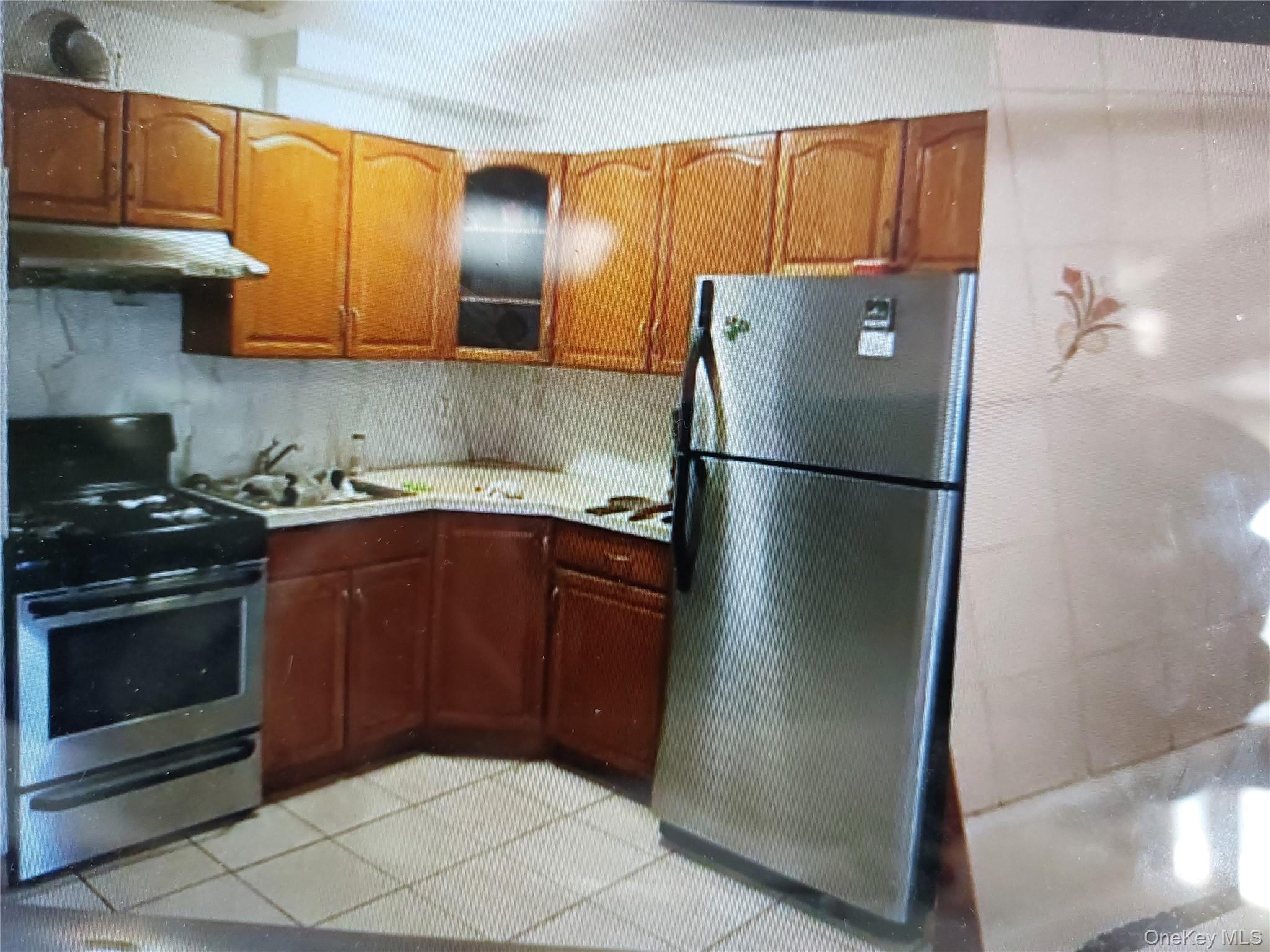 102-14 Lewis Avenue, Unit 2E Queens, NY 11368 - Photo 2 of 5 a kitchen with stainless steel appliances granite countertop a refrigerator a stove and a sink