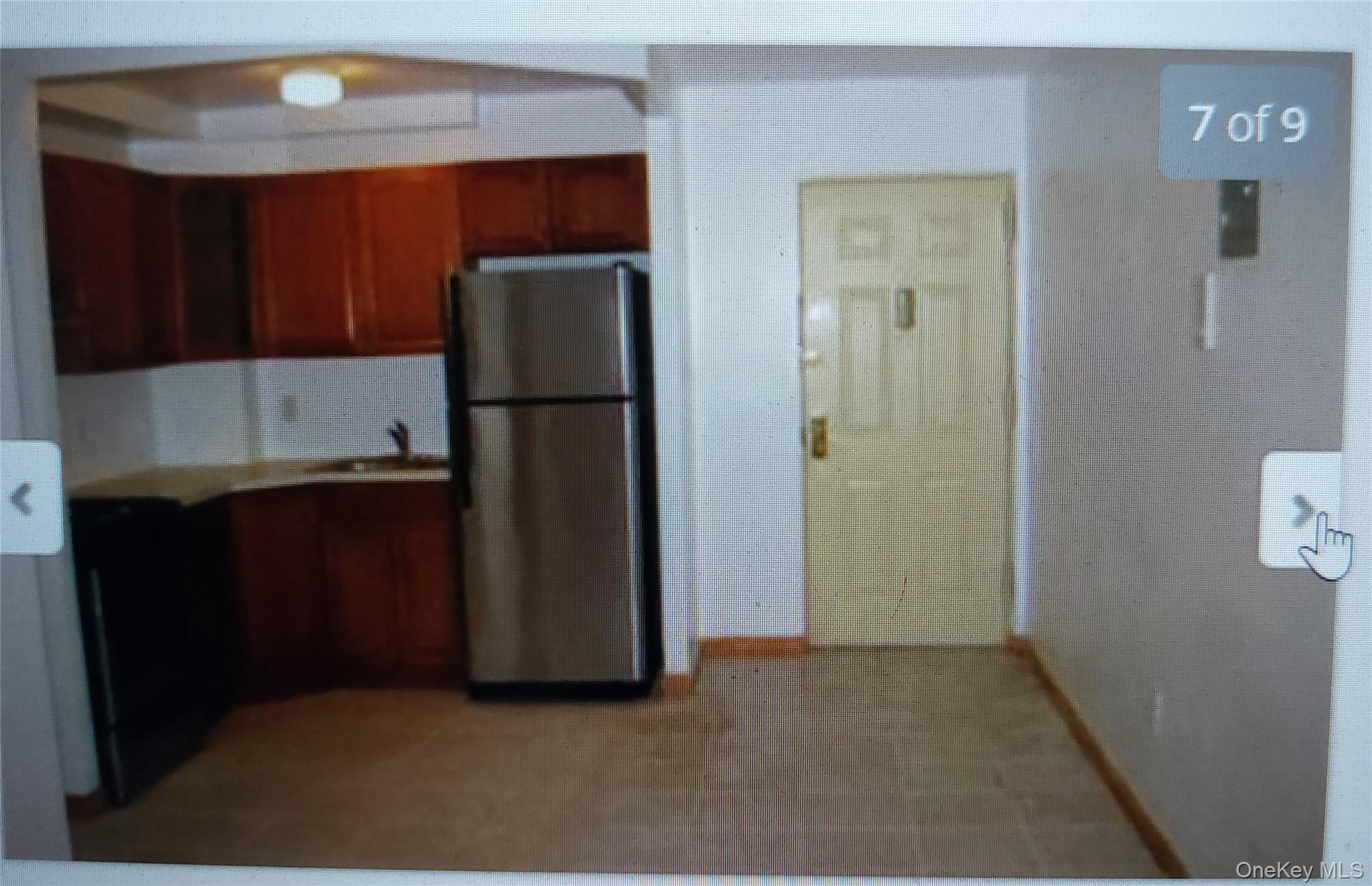 102-14 Lewis Avenue, Unit 2E Queens, NY 11368 - Photo 3 of 5 a kitchen with a refrigerator and cabinets