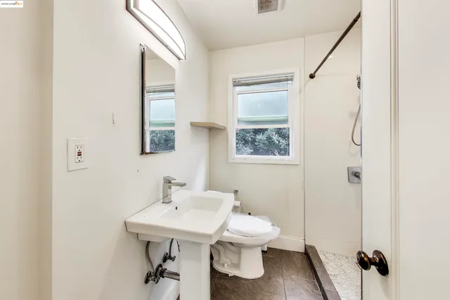 a bathroom with a sink a toilet and a mirror