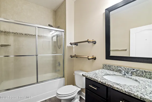 a bathroom with a granite countertop sink toilet and shower