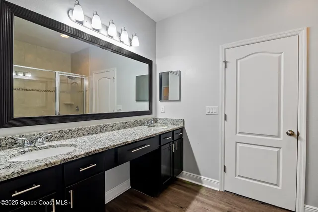a bathroom with a granite countertop sink and a mirror