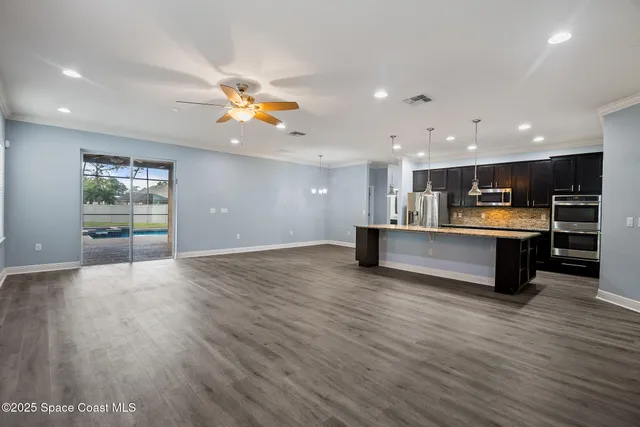 a view of kitchen with kitchen island microwave and wooden floor