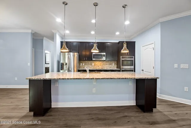 a large kitchen with kitchen island a sink stainless steel appliances and cabinets
