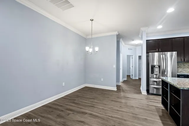 a view of a kitchen with a refrigerator wooden floor and a ceiling fan