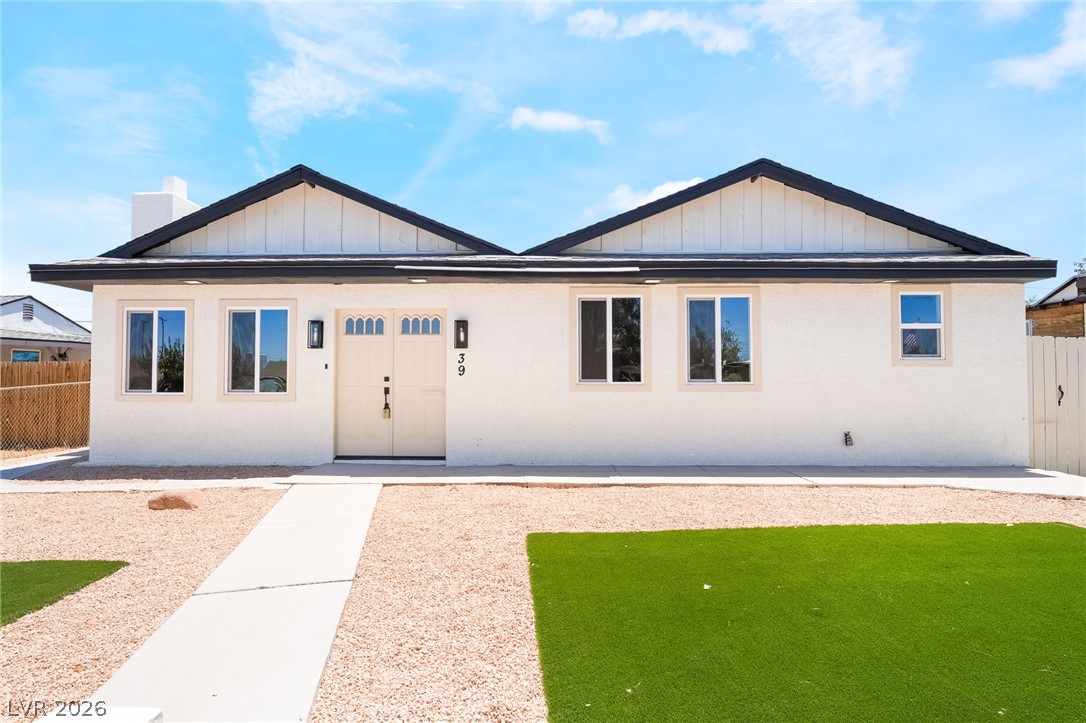 A striking exterior presents a fresh facade with a mix of gravel and green turf for effortless upkeep.