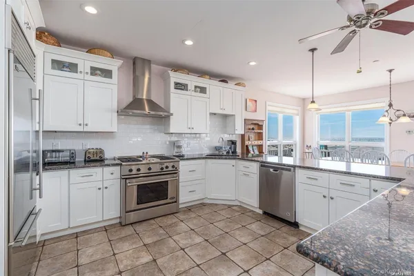 a kitchen with stainless steel appliances granite countertop a stove sink and cabinets