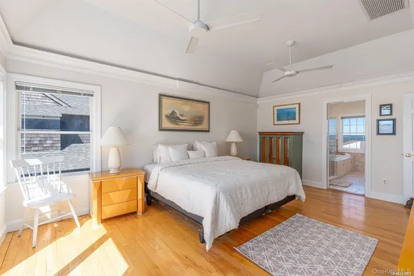 a bedroom with a large bed a rug and windows