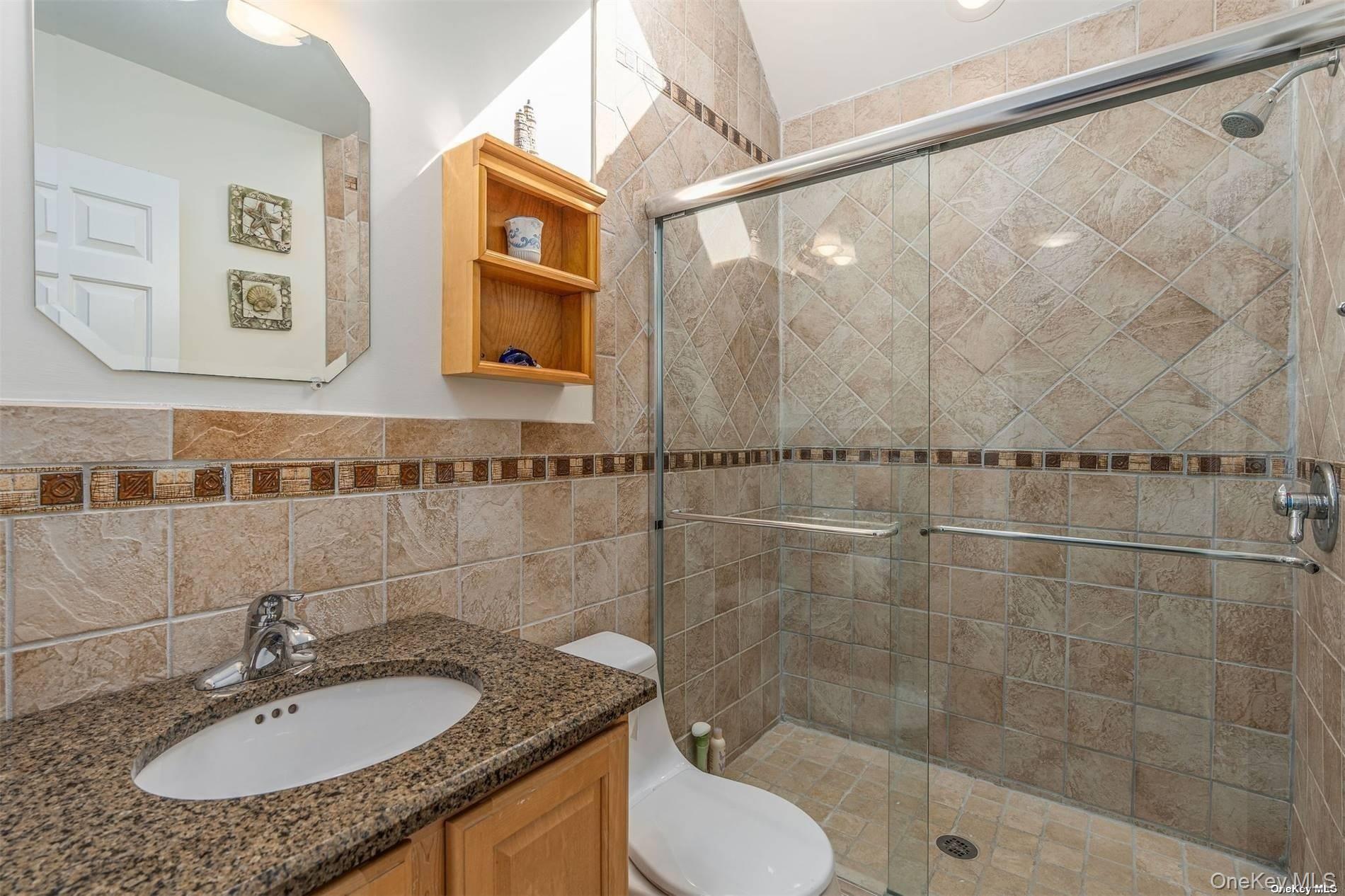 953 B Dune Road Westhampton Beach, NY 11978 - Photo 21 of 36 a bathroom with a granite countertop sink toilet and shower