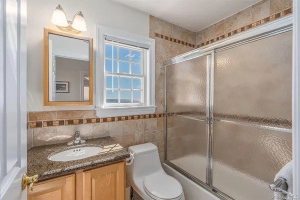a bathroom with a granite countertop sink toilet and shower