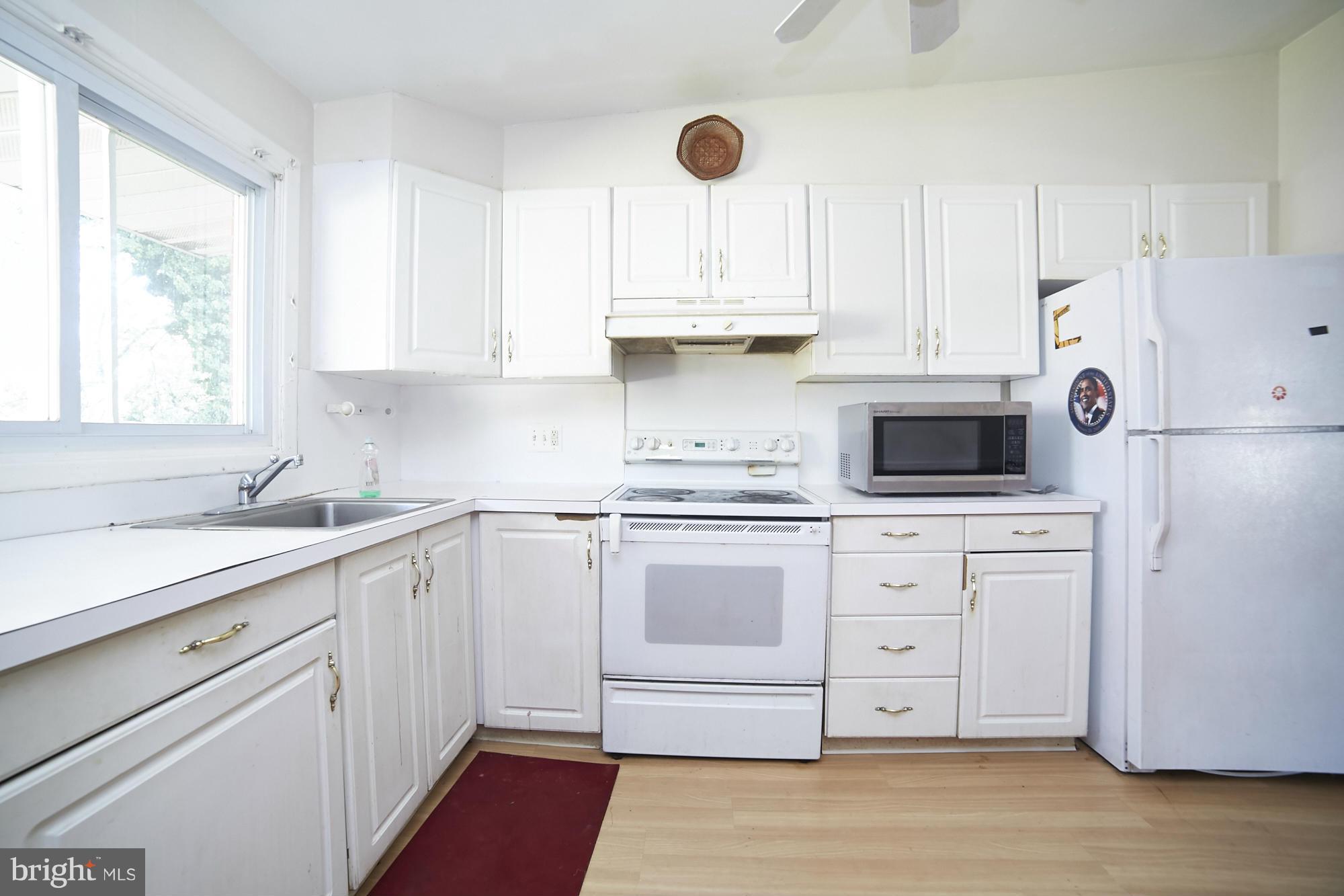 6851 Queens Ferry Road Baltimore, MD 21239 - Photo 11 of 25 a kitchen with cabinets appliances a sink and a window