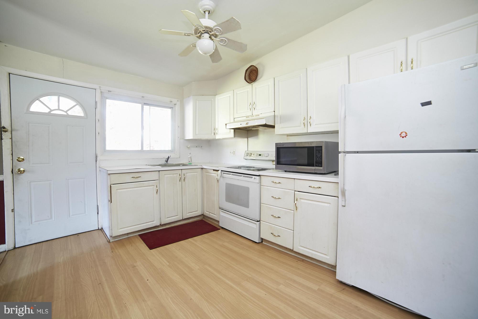 6851 Queens Ferry Road Baltimore, MD 21239 - Photo 12 of 25 a kitchen with cabinets stainless steel appliances and window