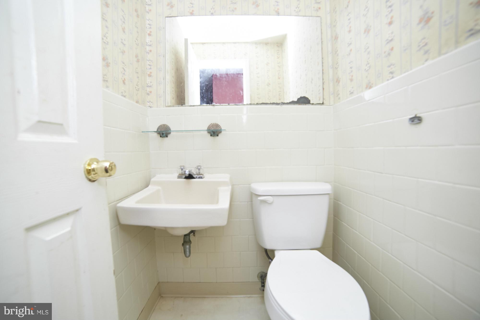 6851 Queens Ferry Road Baltimore, MD 21239 - Photo 13 of 25 a bathroom with a toilet sink and mirror