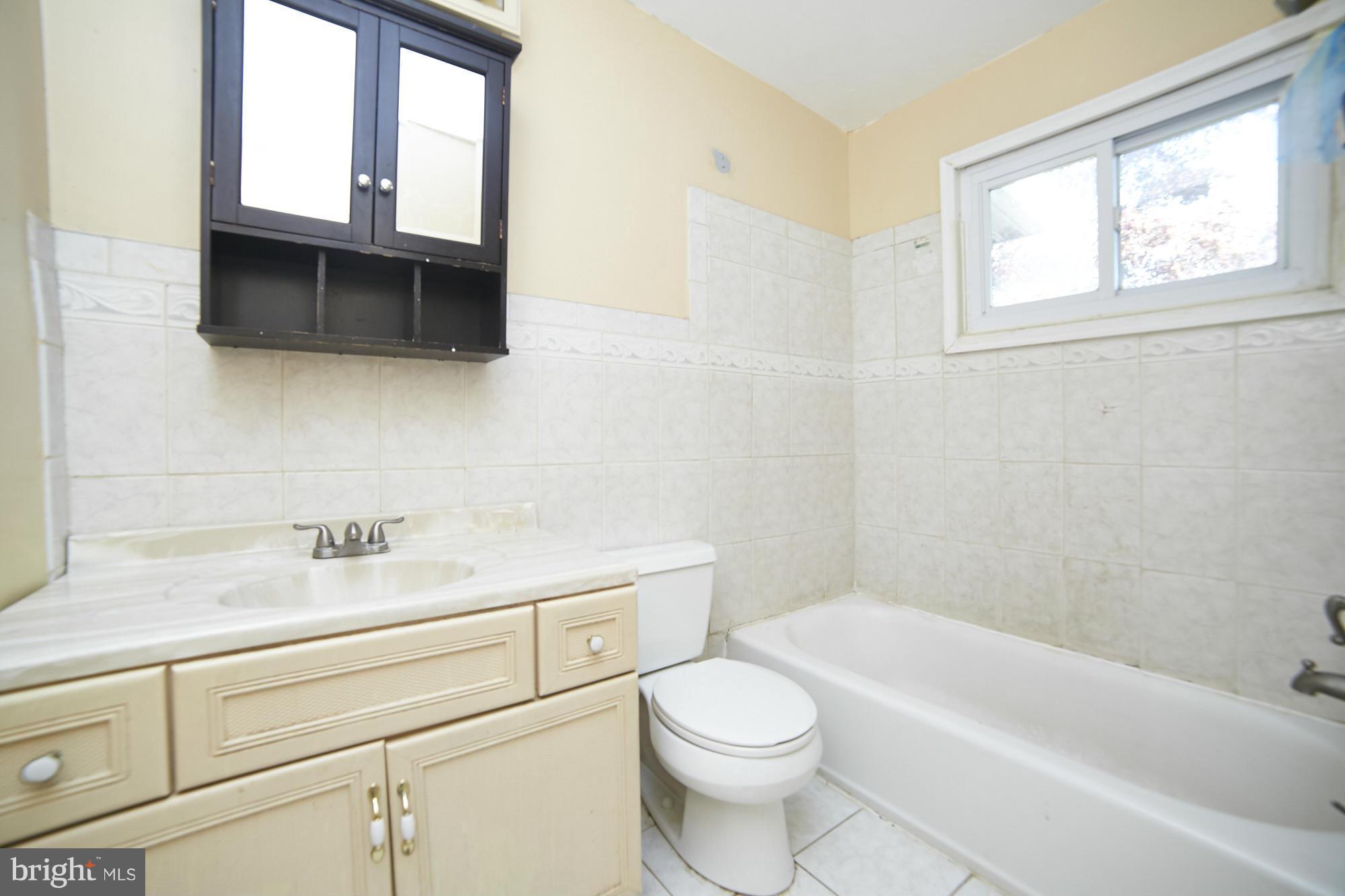 6851 Queens Ferry Road Baltimore, MD 21239 - Photo 20 of 25 a bathroom with a sink a toilet and bathtub