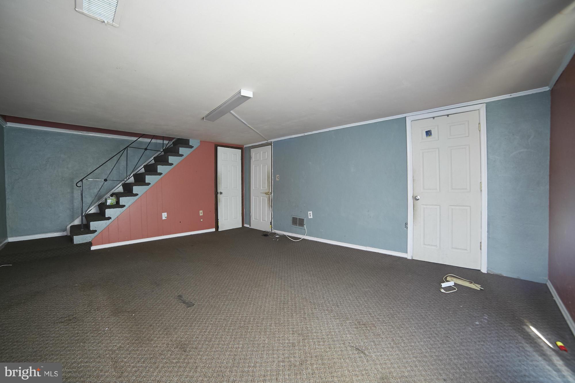 6851 Queens Ferry Road Baltimore, MD 21239 - Photo 22 of 25 an empty room with stairs and windows