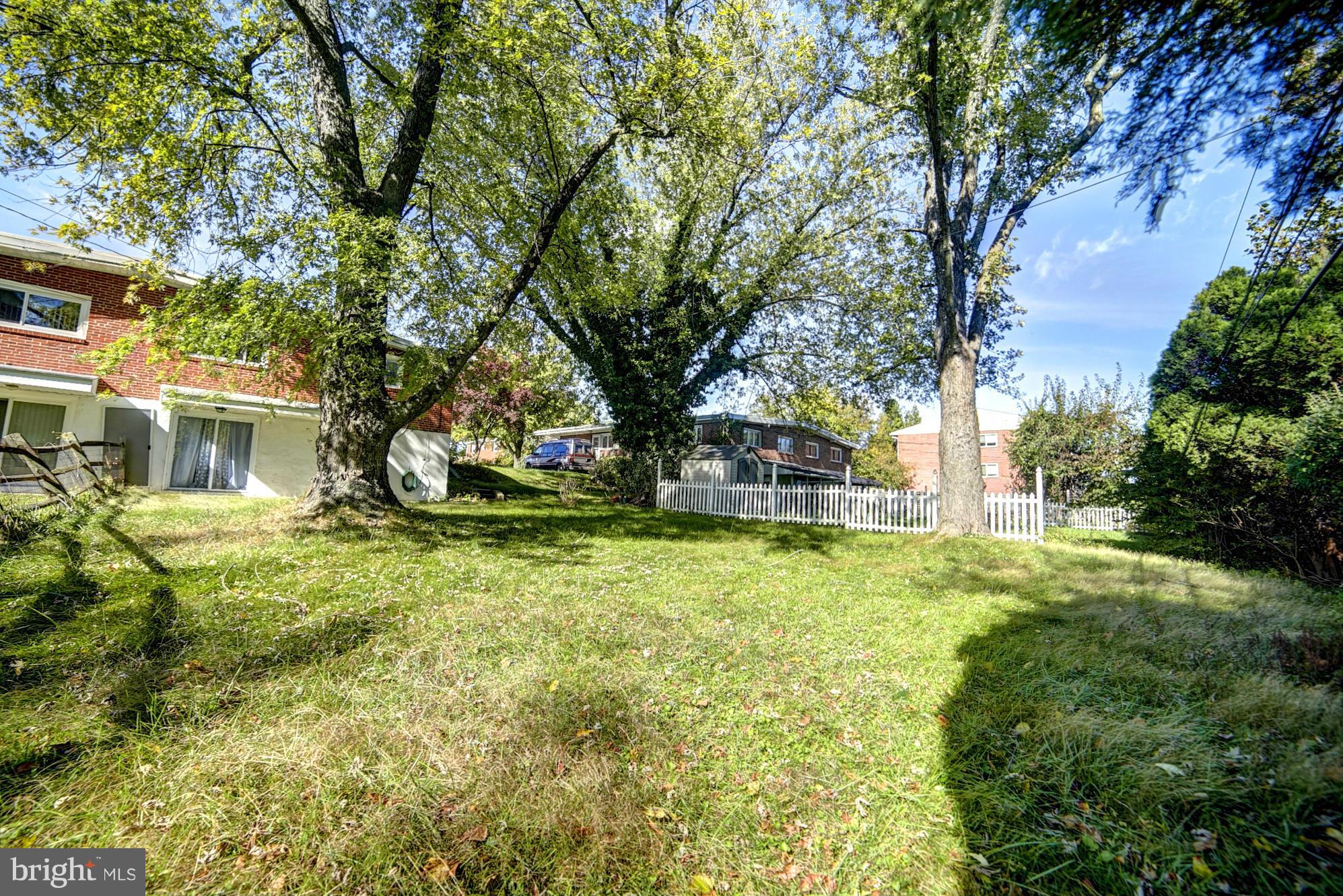 6851 Queens Ferry Road Baltimore, MD 21239 - Photo 24 of 25 a view of a house with a tree and a yard