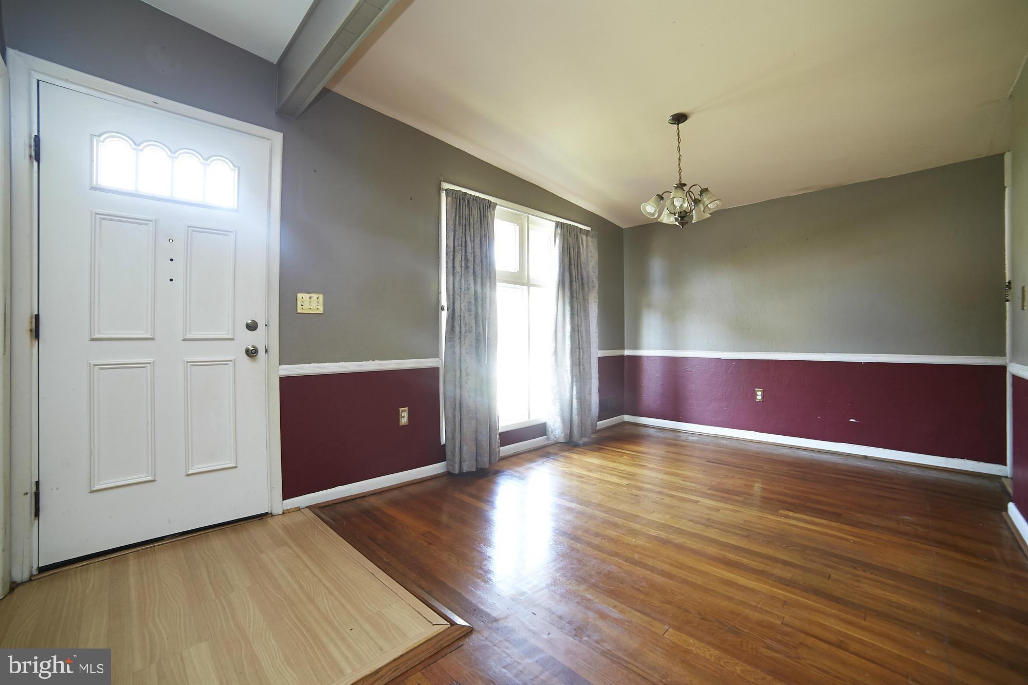 6851 Queens Ferry Road Baltimore, MD 21239 - Photo 4 of 25 a view of an empty room with window and wooden floor