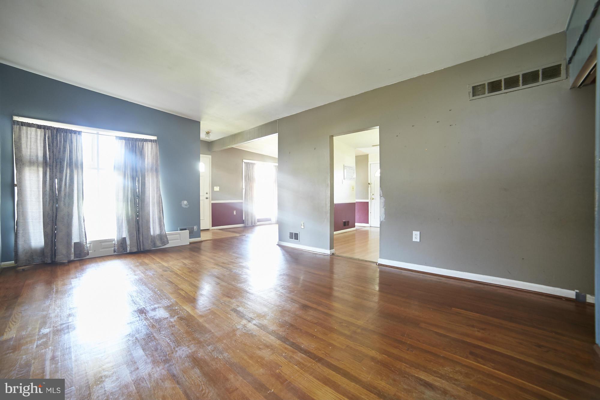 6851 Queens Ferry Road Baltimore, MD 21239 - Photo 7 of 25 a view of empty room with wooden floor and fan