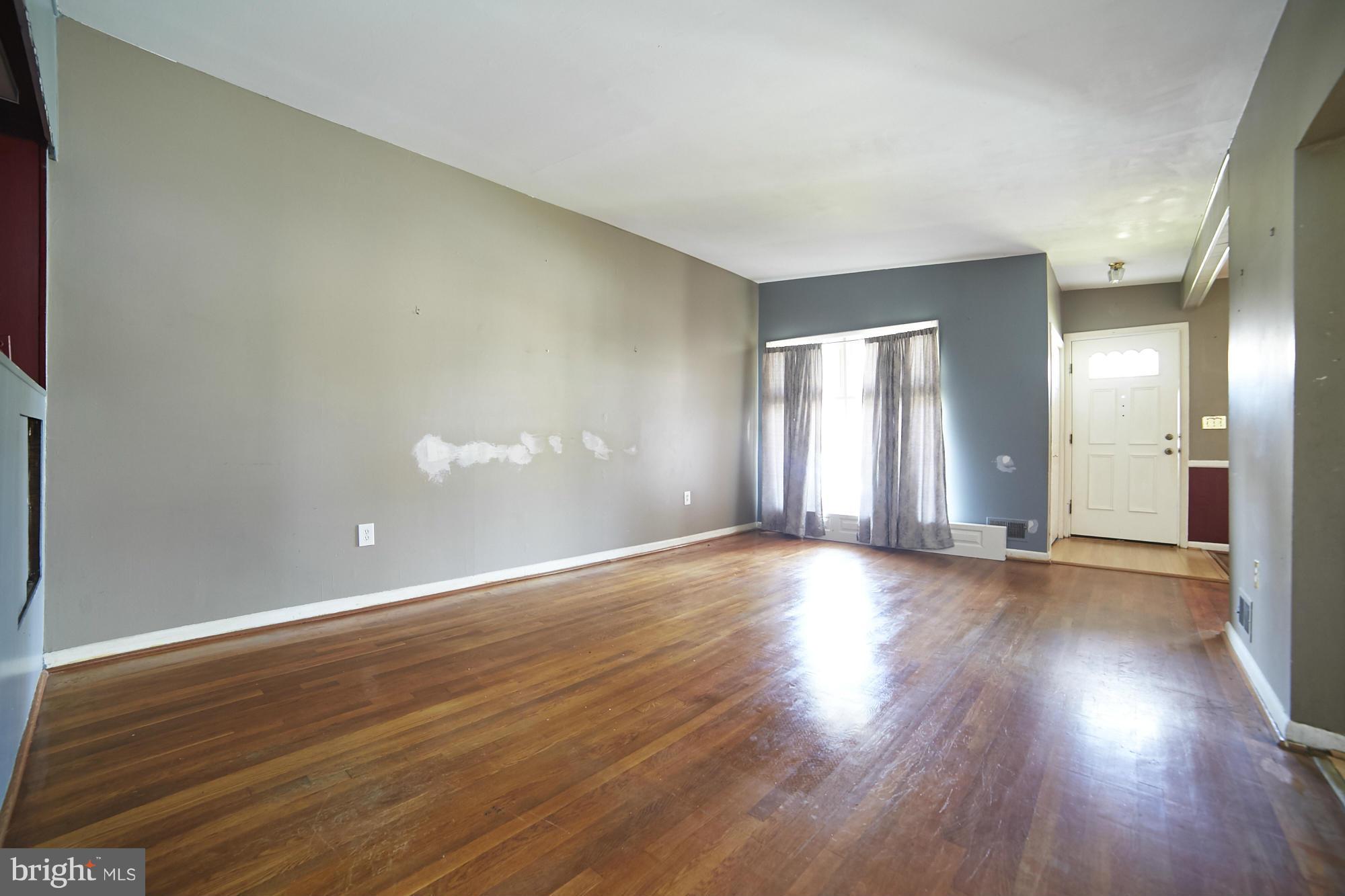 6851 Queens Ferry Road Baltimore, MD 21239 - Photo 8 of 25 a view of an empty room with wooden floor and a window