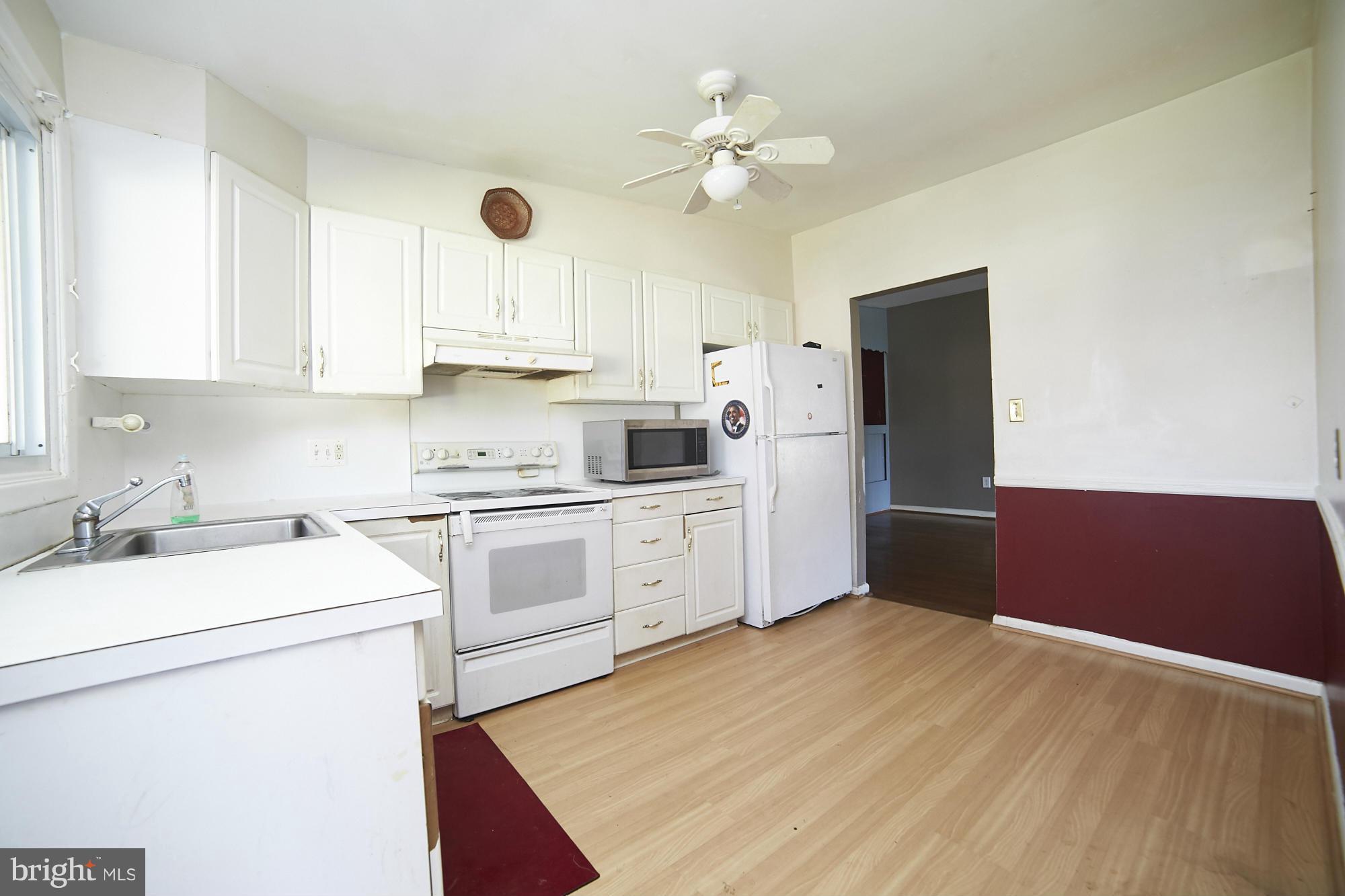 6851 Queens Ferry Road Baltimore, MD 21239 - Photo 9 of 25 a kitchen with a refrigerator sink and cabinets