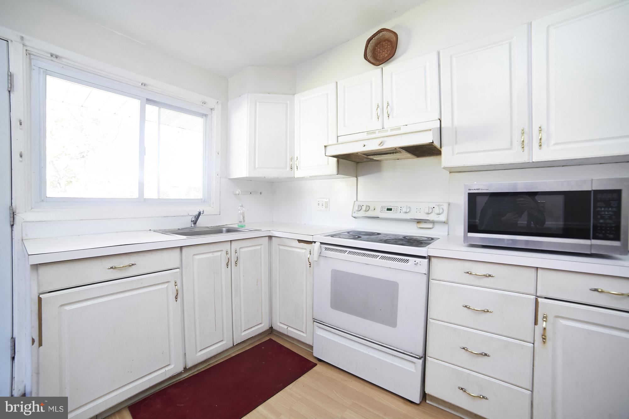 6851 Queens Ferry Road Baltimore, MD 21239 - Photo 10 of 25 a kitchen with cabinets appliances a sink and a window
