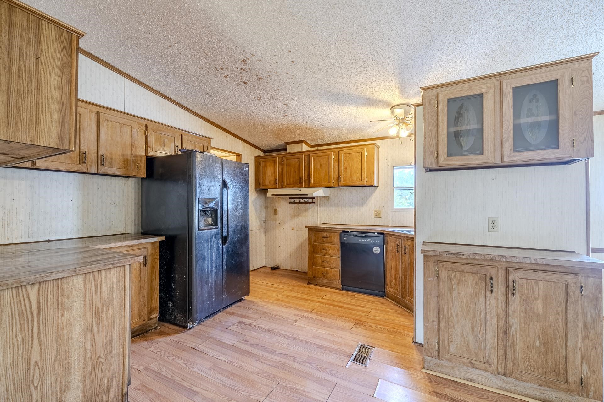 859 Old Morris Chapel Road Adamsville, TN 38310 - Photo 21 of 39 Kitchen featuring wood-finish cabinetry, solid surface countertops, and wood-finish flooring